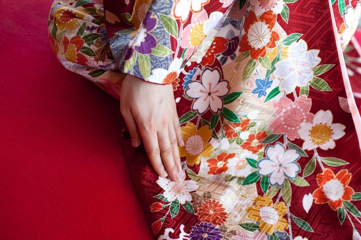 赤系の地に、さまざまな花があしらわれた着物