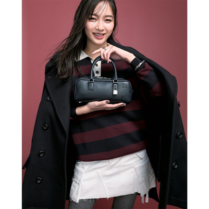 ボーダーのポロニットに白ミニスカートにコートを羽織ってロエベの横長フォルムの黒ミニバッグを持った新川優愛さん