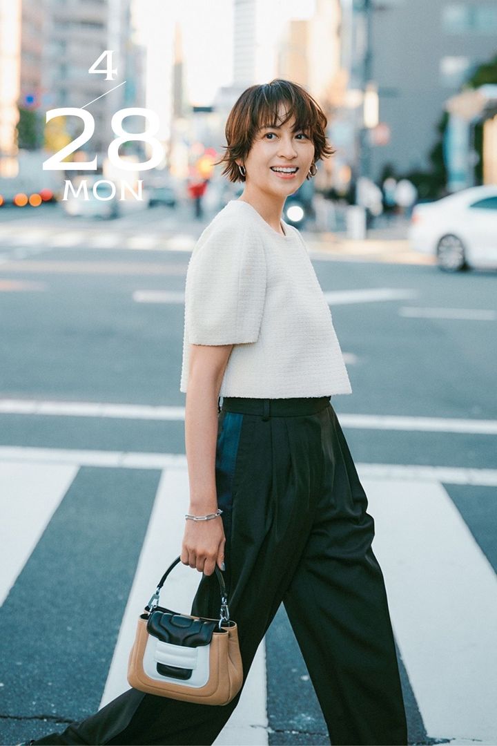 ツイードのショート丈ジャケットとタックパンツを合わせたミニバッグを持った青木裕子さん