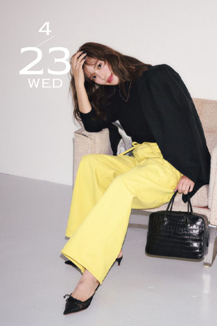 黒のブラウスとジャケットに黄色のカラーデニムを合わせたコーデ