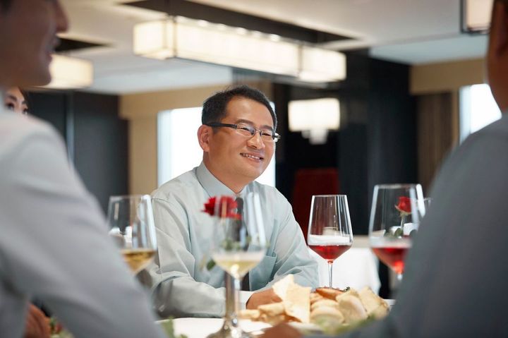 テーブルで男性の同僚と座っているマネジャー