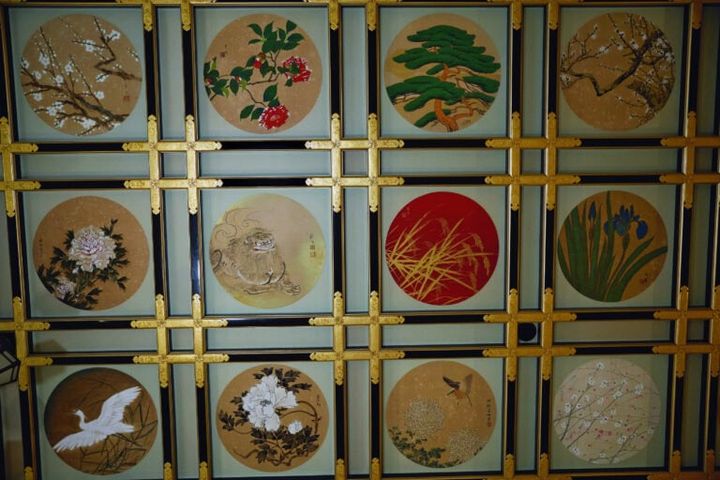 「傘松閣」の2階にある「絵天井の間」。約160畳の大広間の天井を昭和の日本画家144名による230枚の絵画が彩っています。花や鳥の絵の中に5枚だけ動物が混ざっているそうで、ぜひ探してみて。