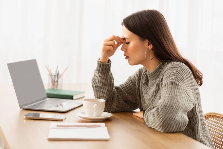 パソコンの前で悩む女性