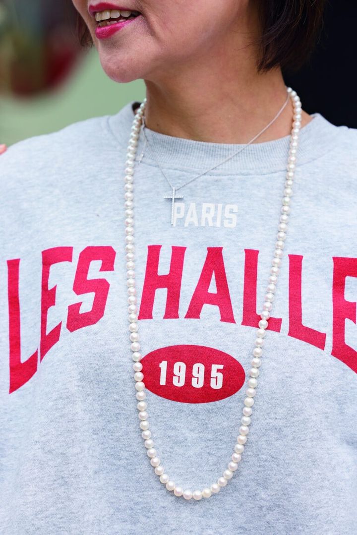 トレーナーの胸元にはパールのロングネックレスとティファニーを重ねづけ。カジュアルがこなれた印象に。