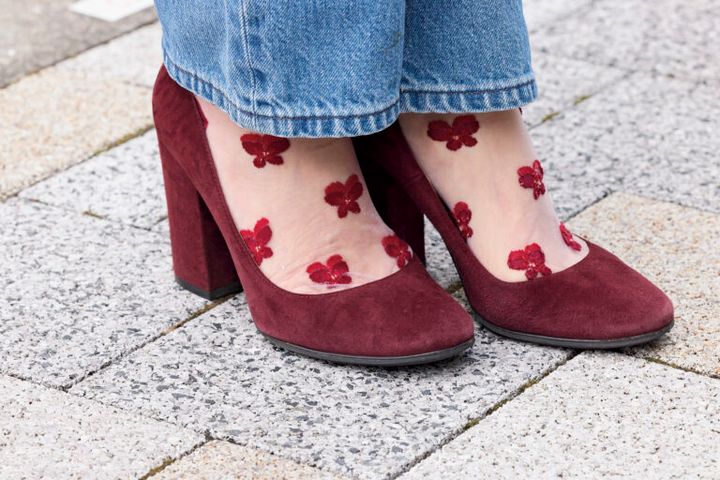 足元はジャンヴィト ロッシのラウンドトゥのヒールをセレクト。同じ色みの花柄の刺しゅう靴下をポイントに。
