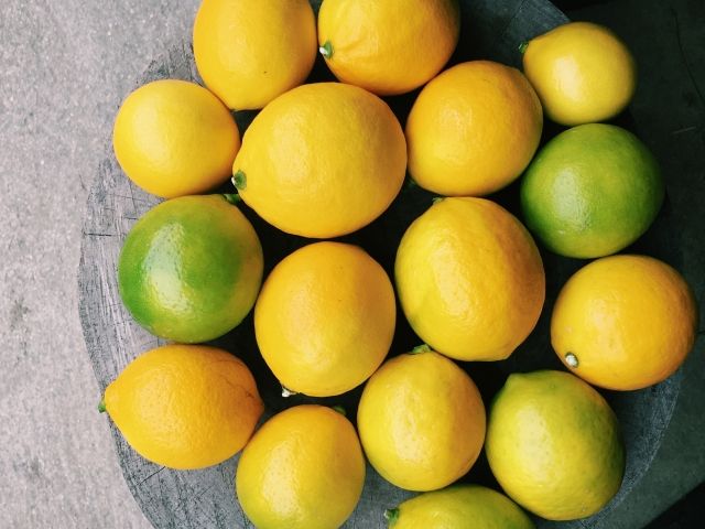 緑のレモンやオレンジのレモンがいくつも置かれている