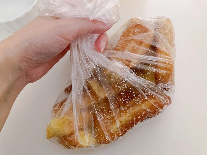 揚げたチュロスにグラニュー糖をまぶす