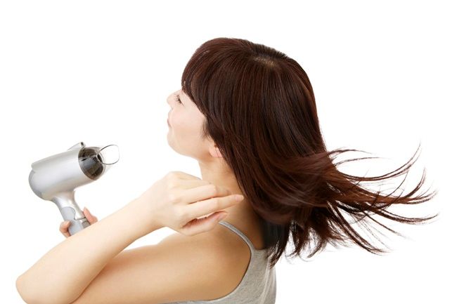 ドライヤーをかける女性