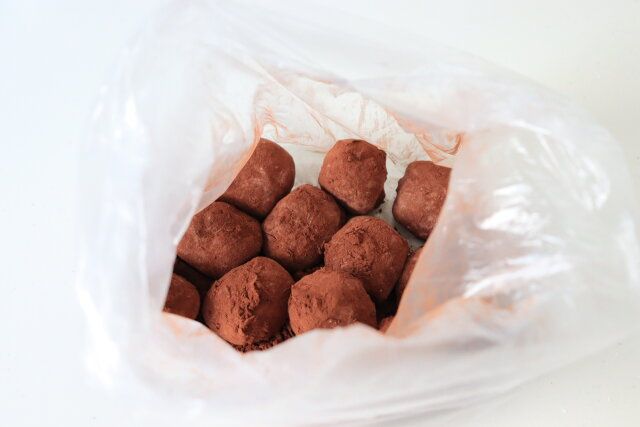 ポリ袋にココアパウダーを入れ、包んだチョコ餅のコーンスターチを軽く落としてから入れる。
