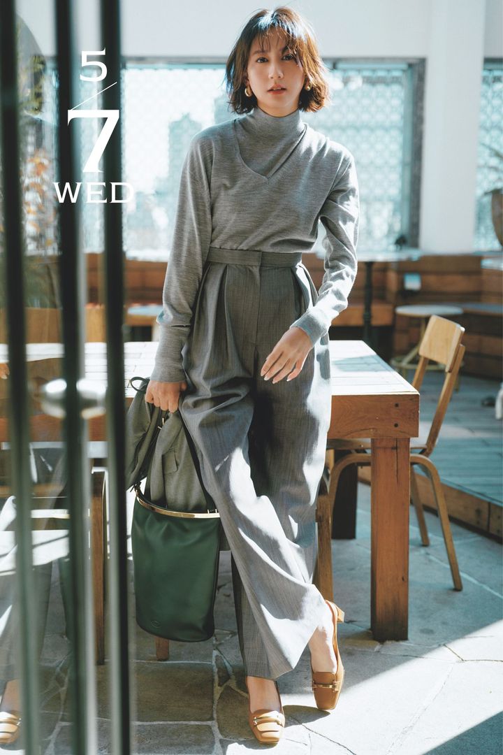 グレーニットの重ね着にグレーのパンツを穿いて足元にブラウンのシューズを合わせた河北麻友子さん