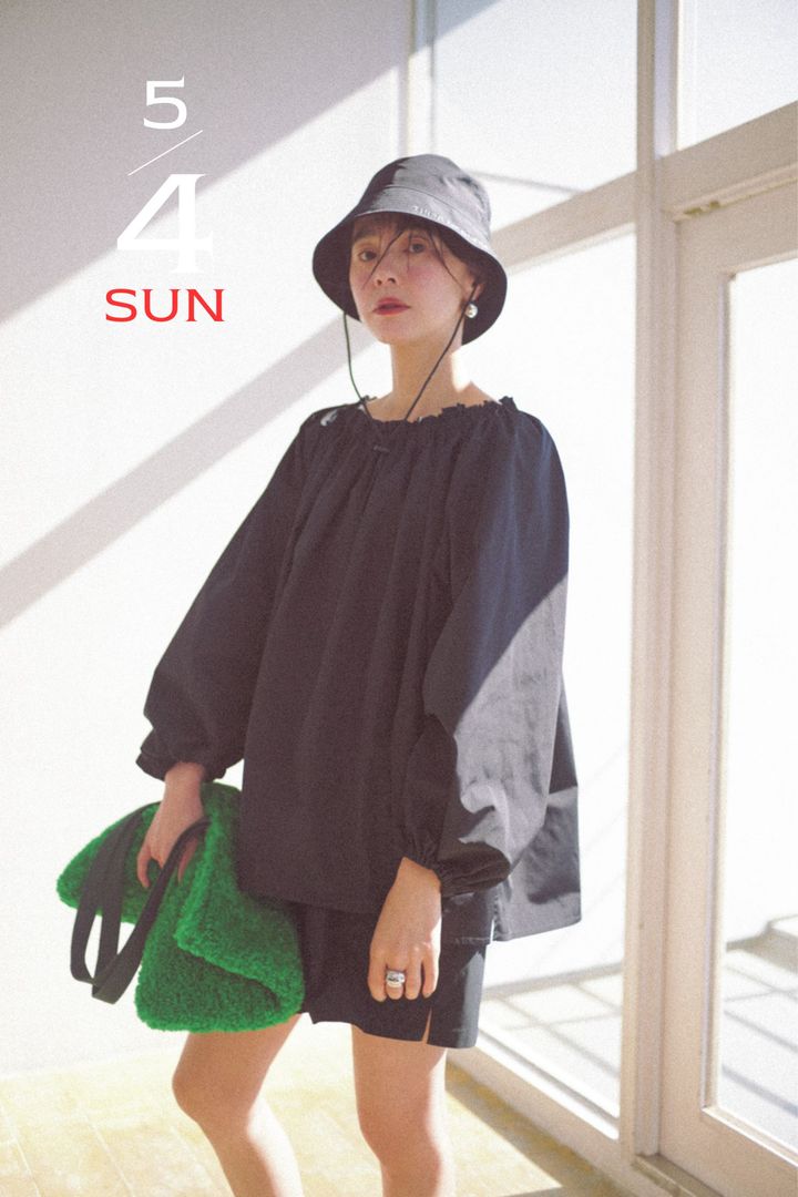 黒の撥水ブラウスとショートパンツに撥水のバケットハットと緑のモコモコバッグを持った浅見れいなさん