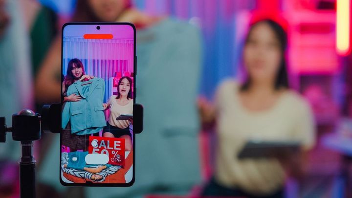 スマートフォンを利用してライブストリーミングを行っているアジア系女性の二人組