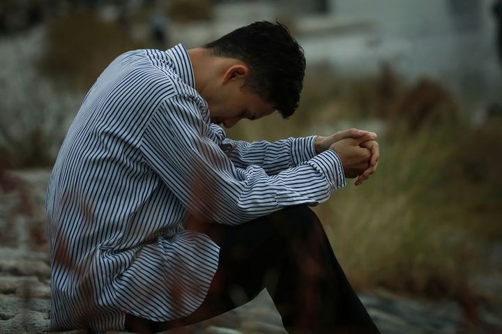 うなだれて座っている男性