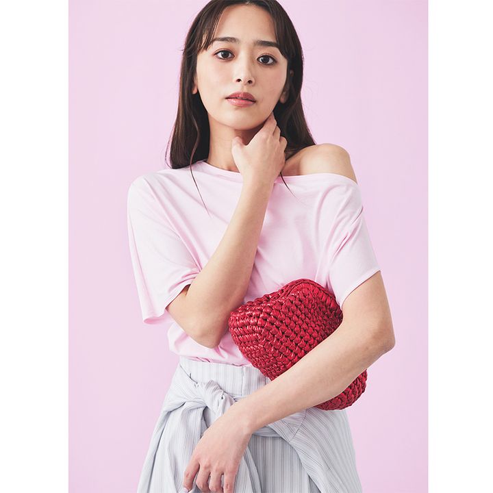 デプレのアシンメトリーデザインのピンクのTシャツとストライプがらのパンツにカゴクラッチを持った近藤千尋さん