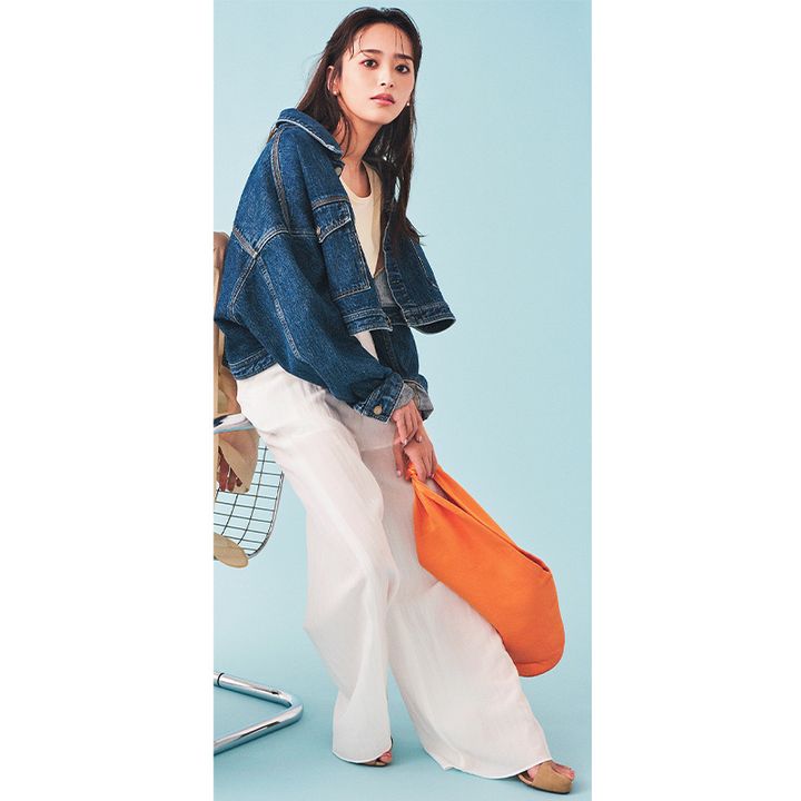 ショート丈Gジャンと白パンツにオレンジ色のバッグを持った近藤千尋さん