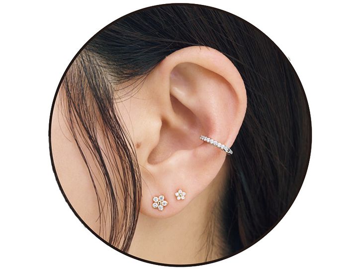 華奢なお花モチーフのピアスふたつとダイヤモンドのイヤーカフを重ねづけした耳元
