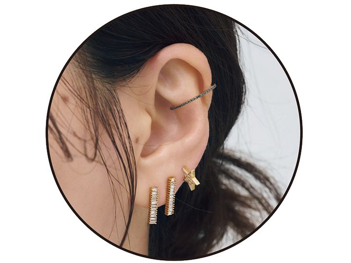 華奢なバーデザインのピアス2つと星のピアスとイヤーカフを重ねた耳元