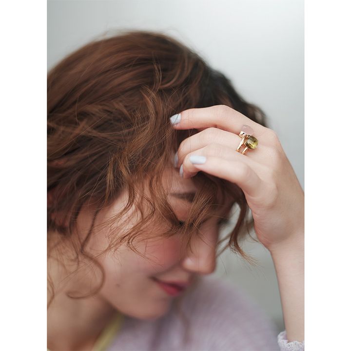 髪を巻いて手元にポメラートの色石指輪を重ねづけした辻元舞さん