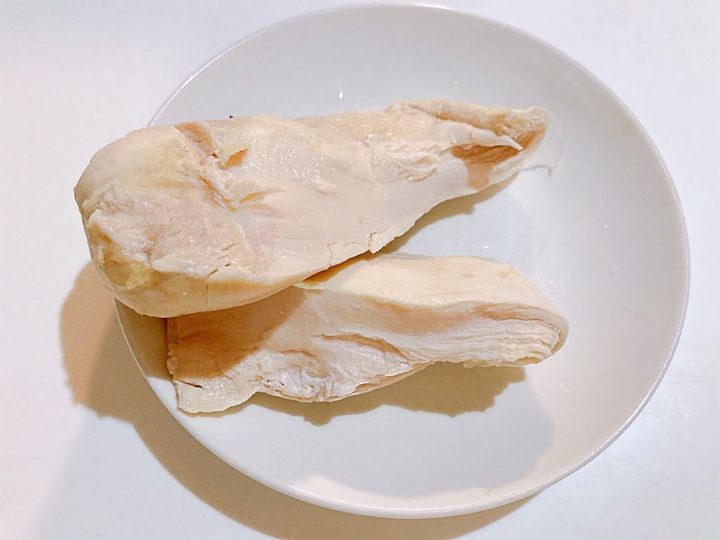 茹でた鶏むね肉を大きく割いて火の通りを確認する