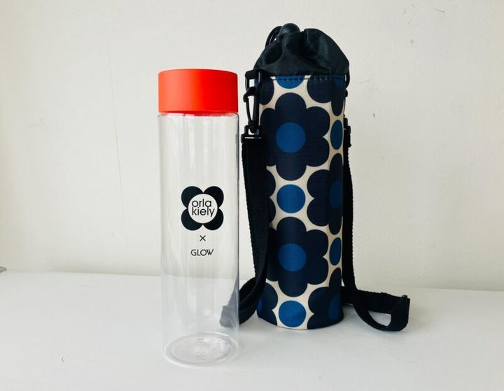 オレンジのキャップが華やかなロゴ入りクリアボトル。肩掛けストラップ付の保冷ボトルケース。ストラップは取り外し可能。