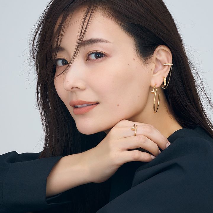 カルティエのLOVEのシングルイヤリングとジュストアンクルのフープピアスを片耳に重ねづけして手元にジュストアンクルのリングをはめた原田夏希さん