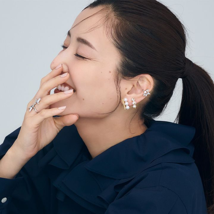 ネイビーブラウスを着た耳元にTASAKIのイヤーカフとイヤリングとピアスを重ね付けした原田夏希さん