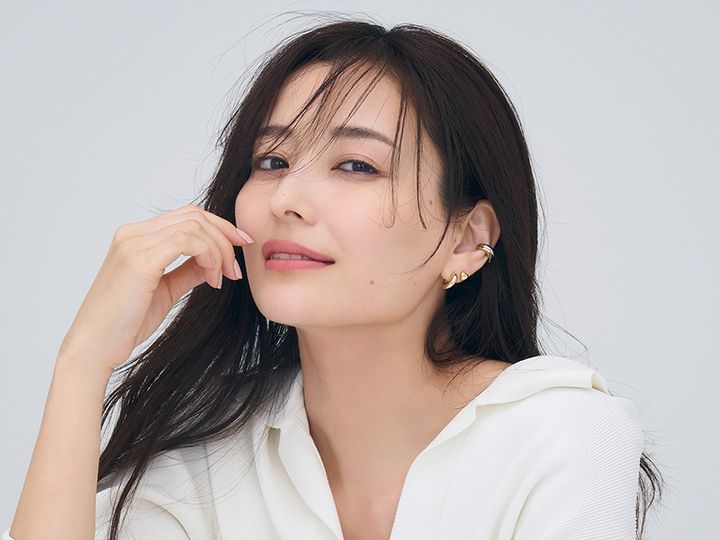 白ニットを着て耳元にイヤーカフとピアスを重ねづけした原田夏希さん