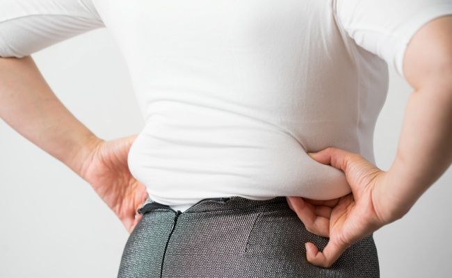 ぜい肉をつまむ女性