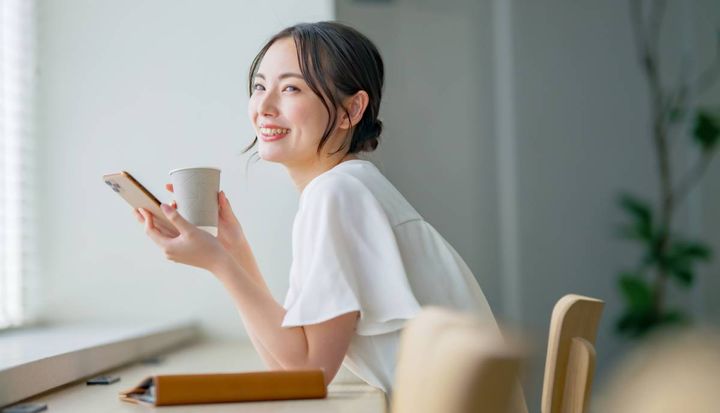 カフェで携帯電話を操作する女性