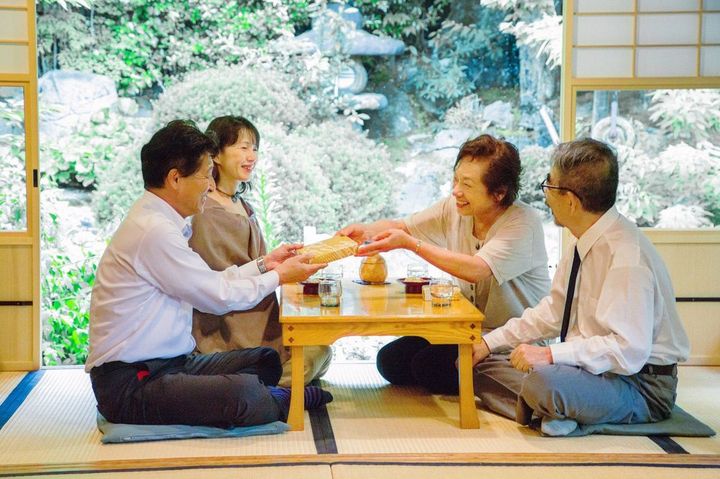 会食の場でお土産を渡す女性
