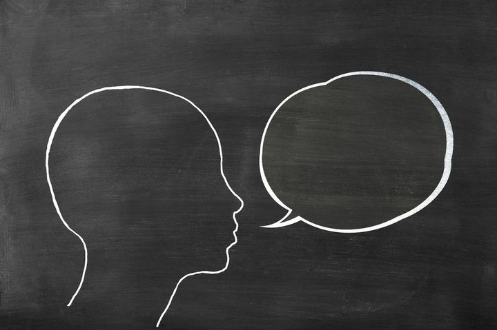 黒板にチョークで描かれたヒトの頭部と吹き出し