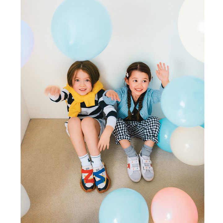 男の子と女の子がおしゃれな靴を履いて座っている様子