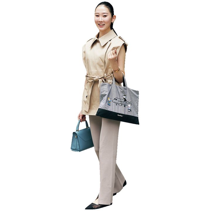 ベージュのジレとパンツに水色のハンドバッグとファミリアとANAコラボのトートを2個持ちしたVERY読者