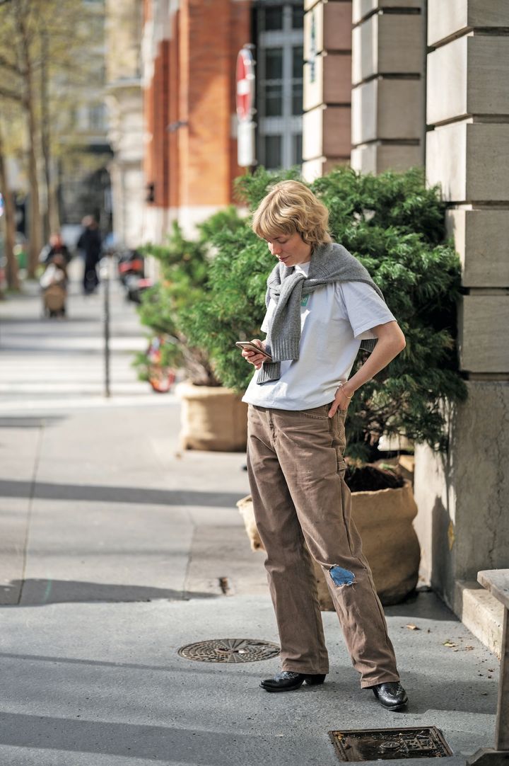 肩にかけた上着がポイント。こなれ感のあるおしゃれな着こなし