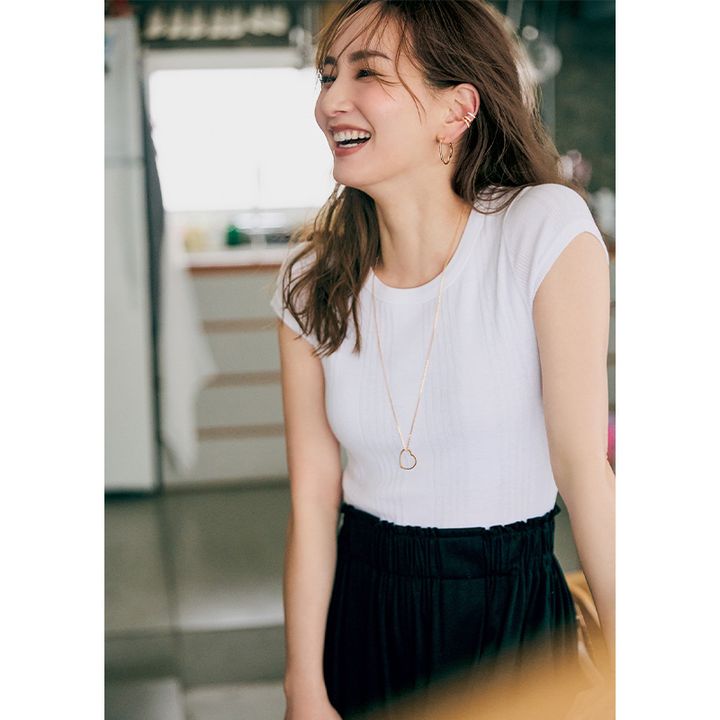 白Tシャツと黒パンツのシンプルコーデを耳元のイヤーカフとハートのピアスとハートのロングネックレスで盛り上げた着こなし