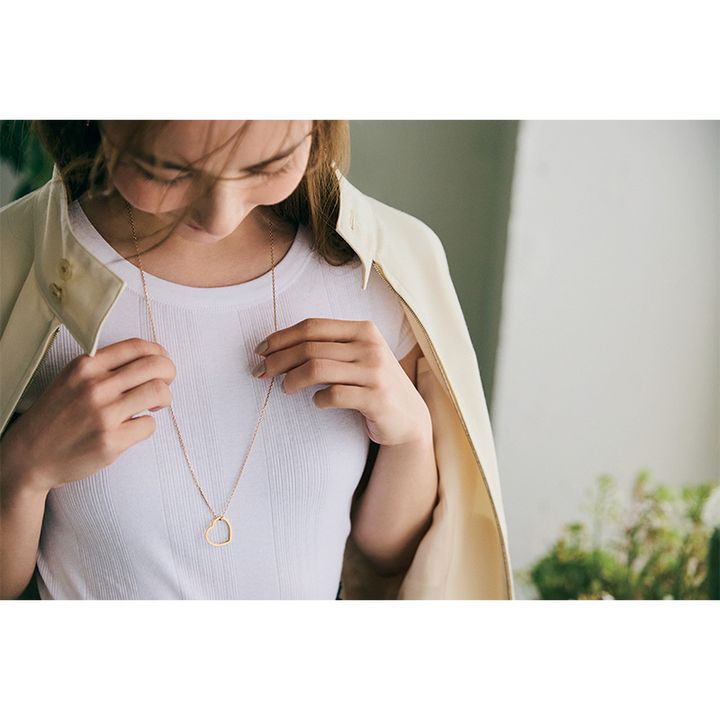 白Tシャツの胸元にチェーンにハートのモチーフがついたロングネックレスを合わせた辻元舞さん