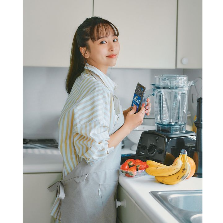 ストライプシャツにエプロンを身につけた近藤千尋さんがミキサーを手にアサイーボウルを作るところ