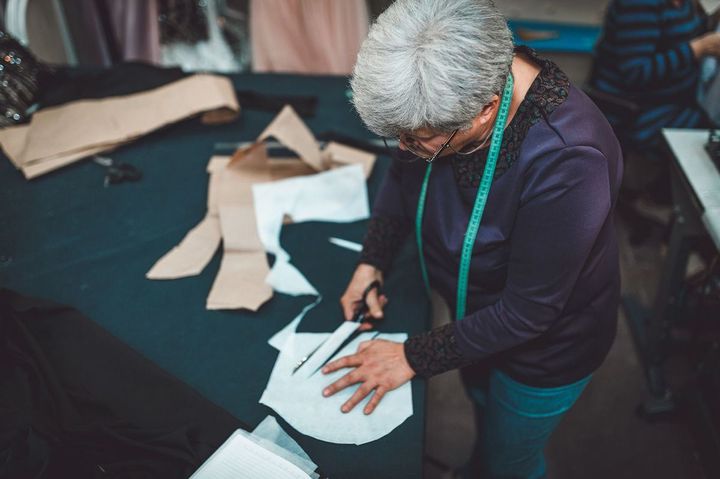 服を作る仕事をする高齢女性