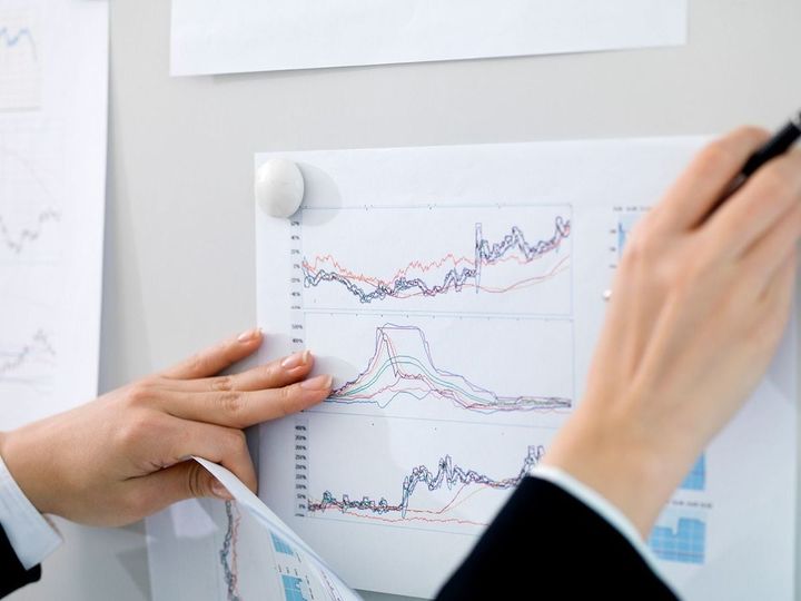 ホワイトボードにグラフの資料を貼る人
