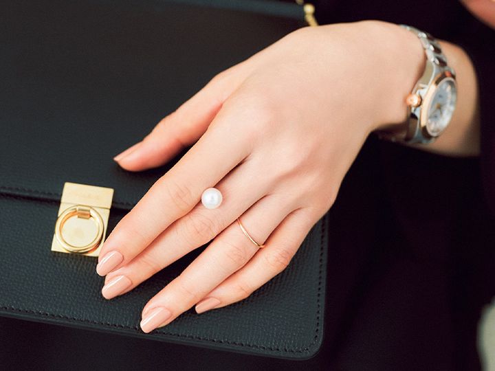 ベージュのネイルカラーでバッグに手を置くイメージカット