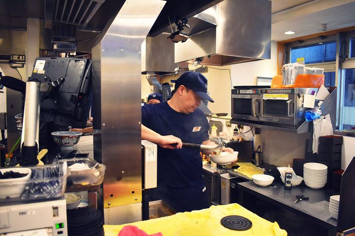 カレーに肉を盛る奥村