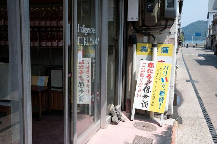 八田保命酒舗の外観。道の先に「仙人が酔うほど美しい」とうたわれる仙酔島が見える