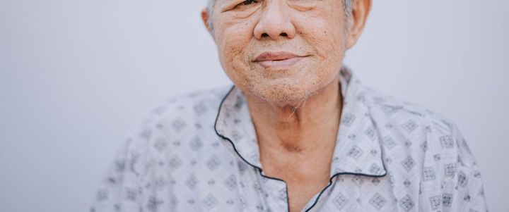 パジャマ着用でカメラを見つめるシニア男性