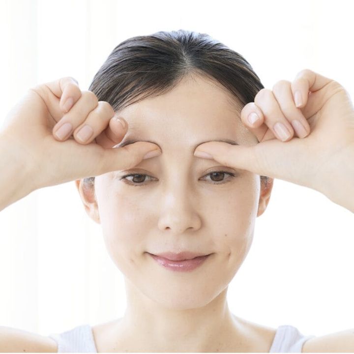 眉頭の下のツボを押す