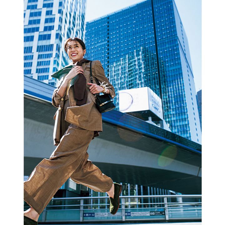 ブラウン系のスーツにニットを肩掛けしてショルダーバッグとローファーを合わせたお仕事コーデの笹川友里さん