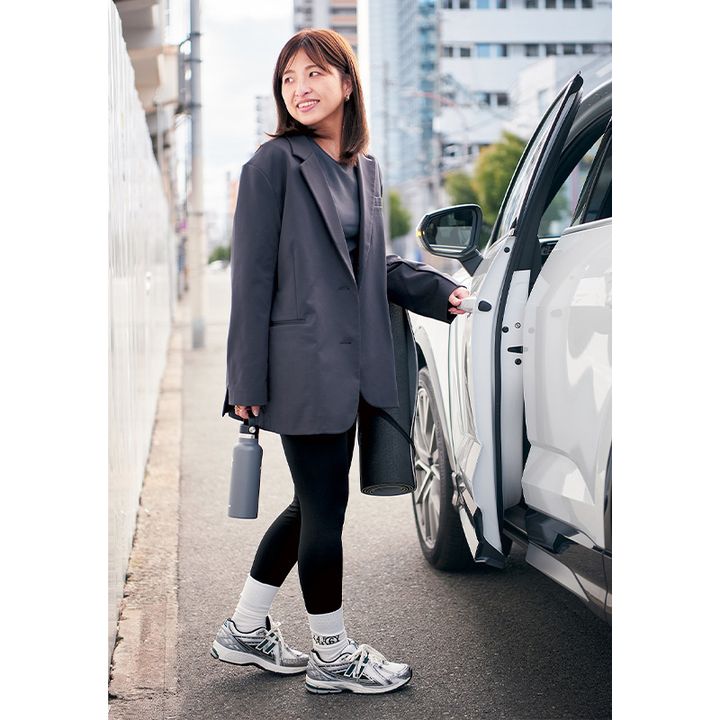 ピラティスコーデにジャケットを羽織って車に乗り込む様子