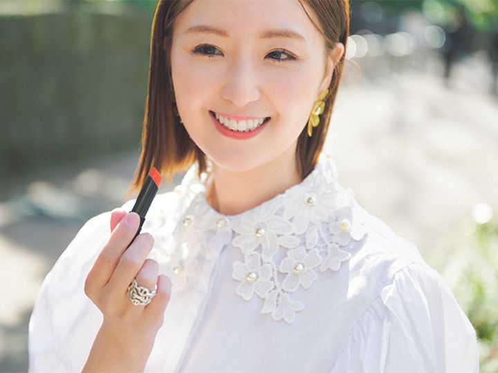 白の甘デザインのシャツを着てセルヴォークのリップを持つVERY読者