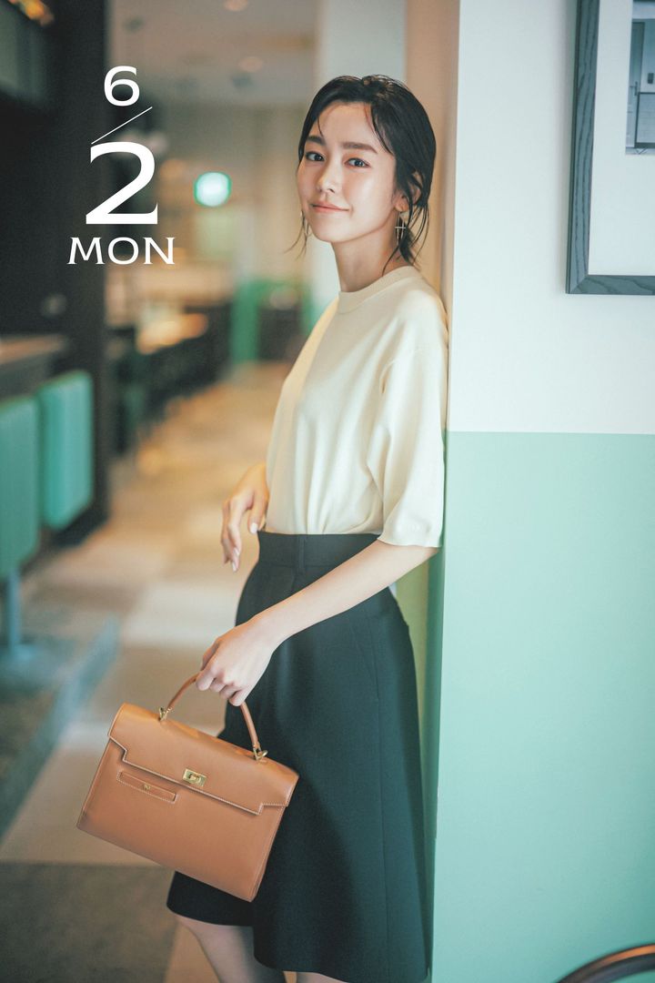 五分袖ニットとハーフパンツにキャメルのハンドバッグを持った桐谷美玲さん
