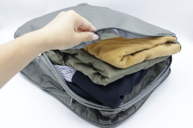 スタンダードプロダクツの圧縮バッグに衣類を収納する様子