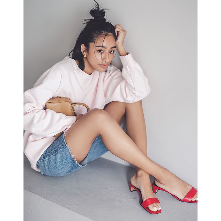 エイトンのスウェットとSEAの切りっぱなしのハーフデニムに赤のバーサンダルやキャメルのバッグを合わせた佐貫まやさん